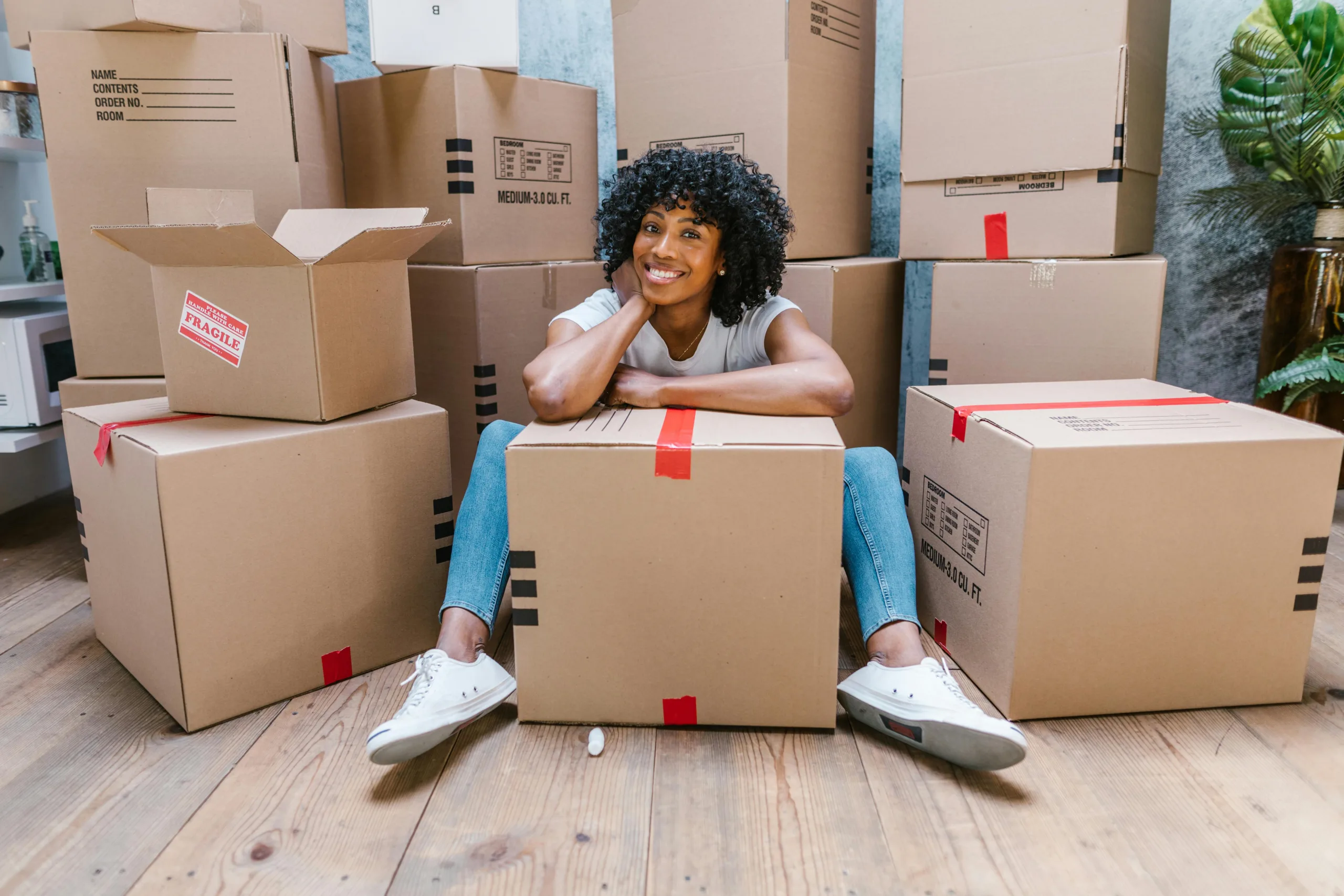 Nice lady smiling whilst packing boxes ready to move house