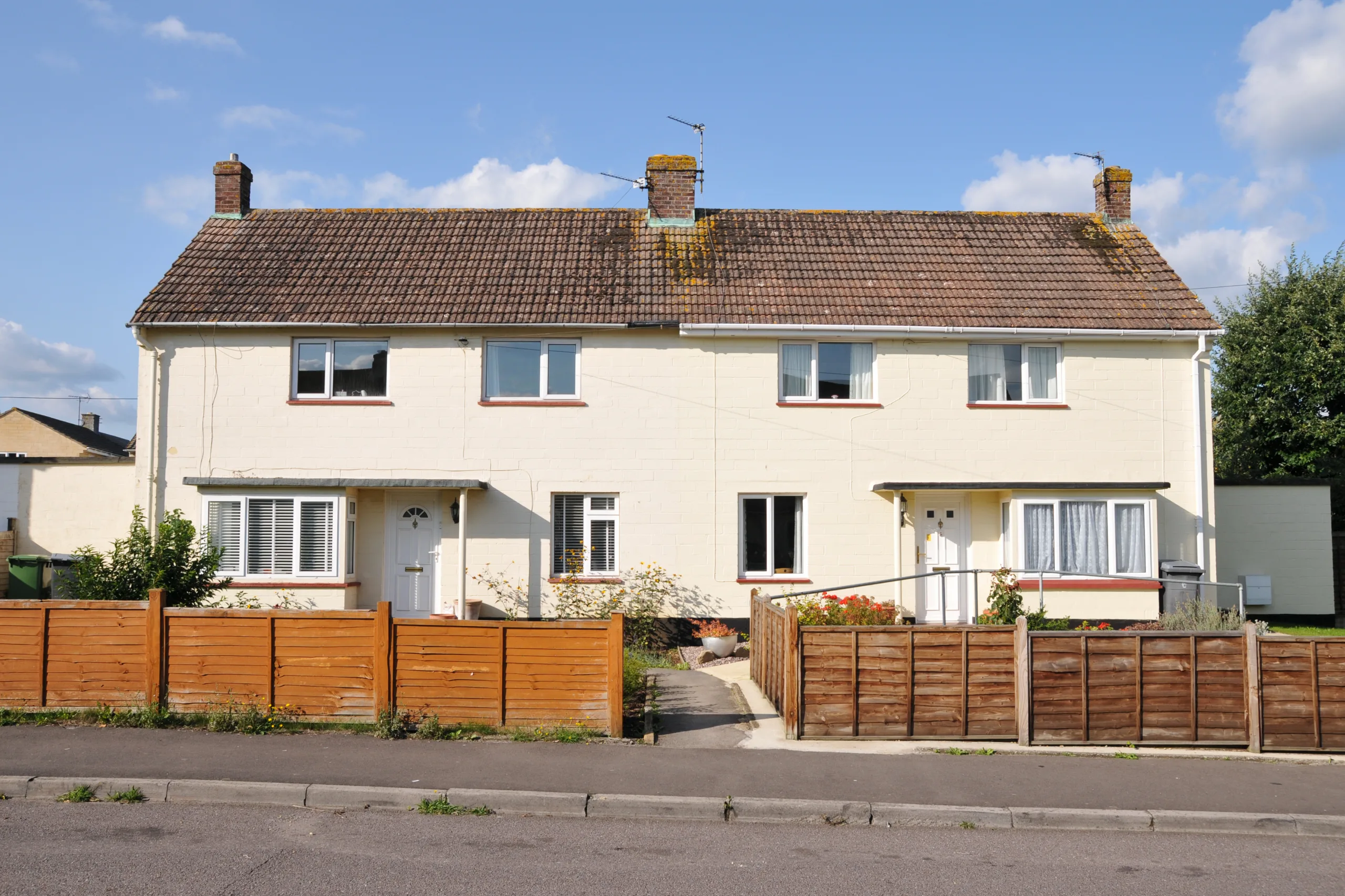 Non-standard construction property. Row of homes with small front gardens.