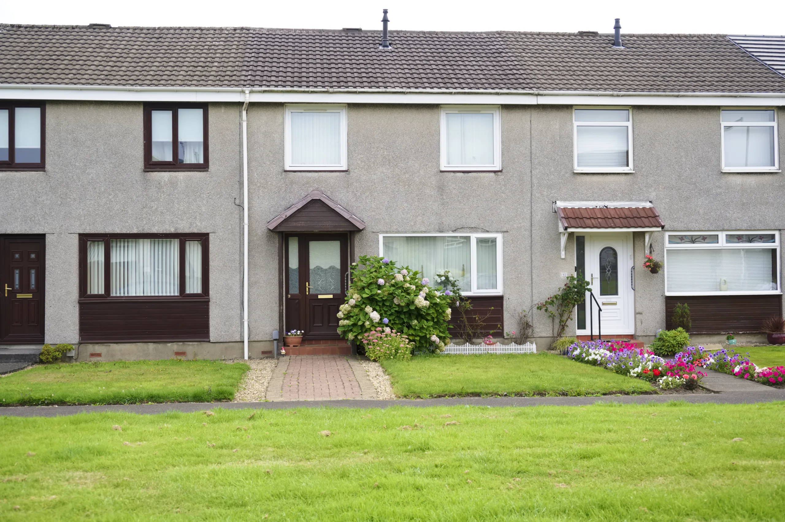 Non-standard construction property. Row of homes with small front gardens.