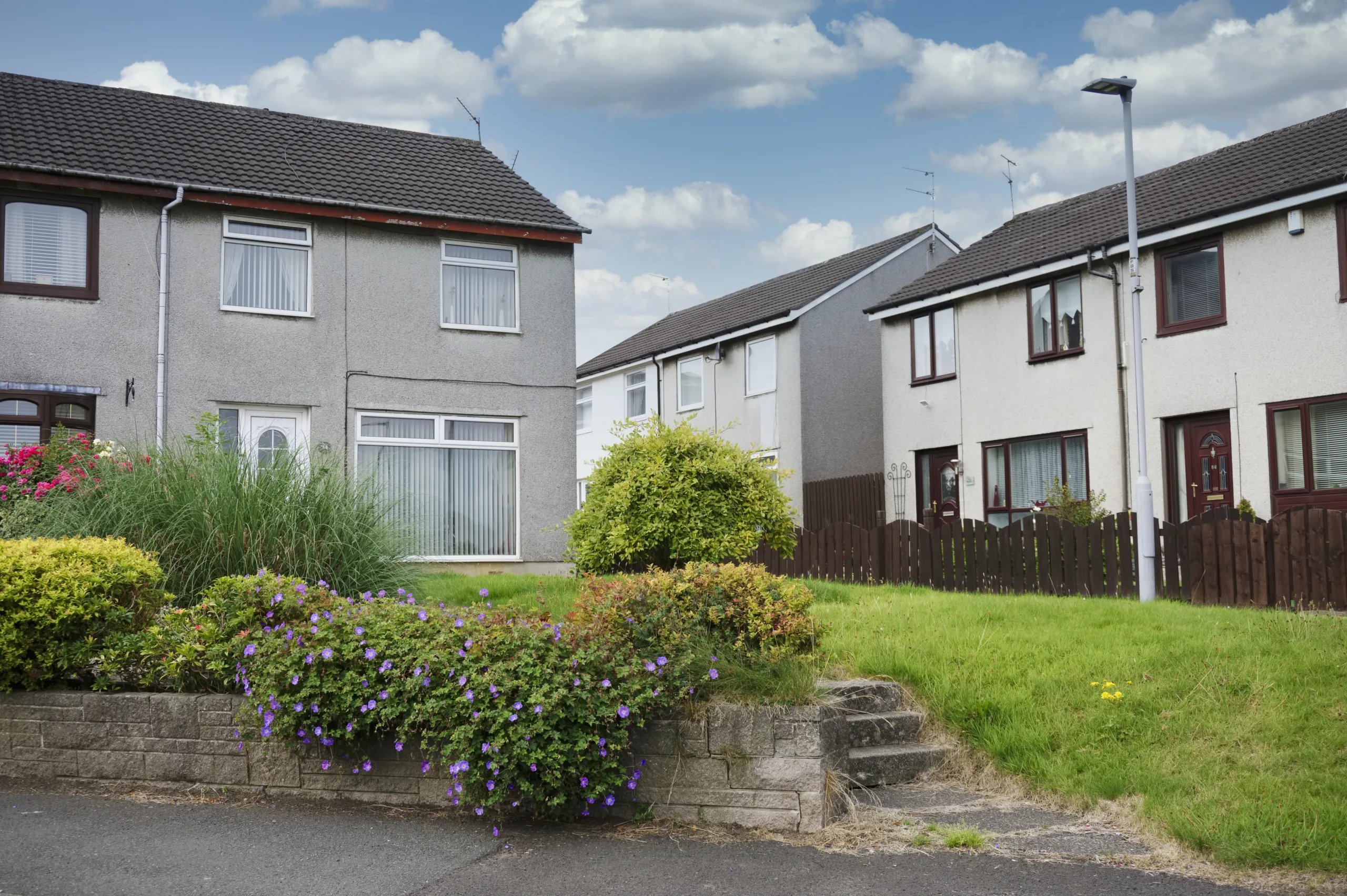 Non-standard construction property. Row of homes with small front gardens.