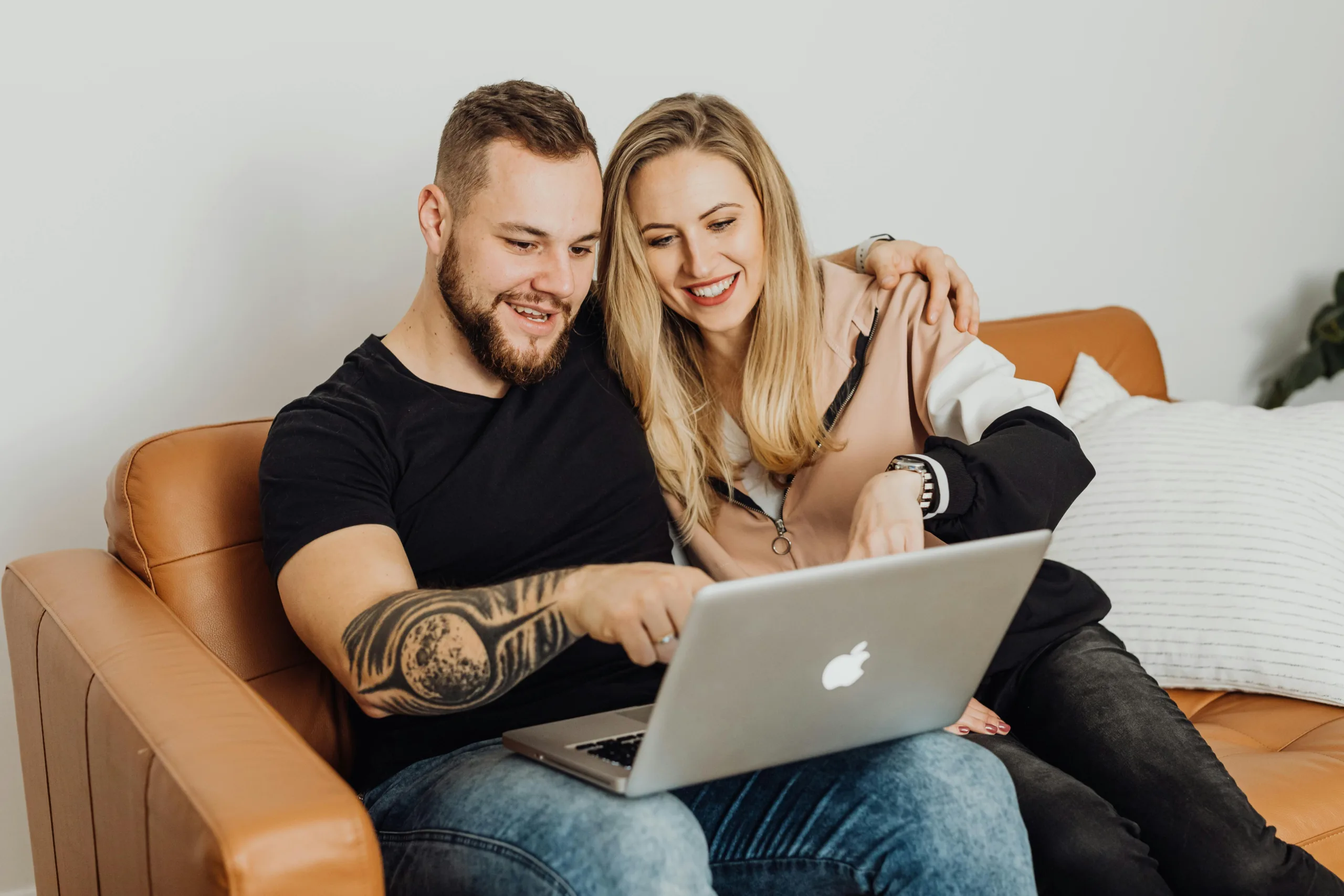happy young couple looking at a laptop
